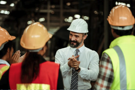 Manager encouraging his team of manufacturing workers