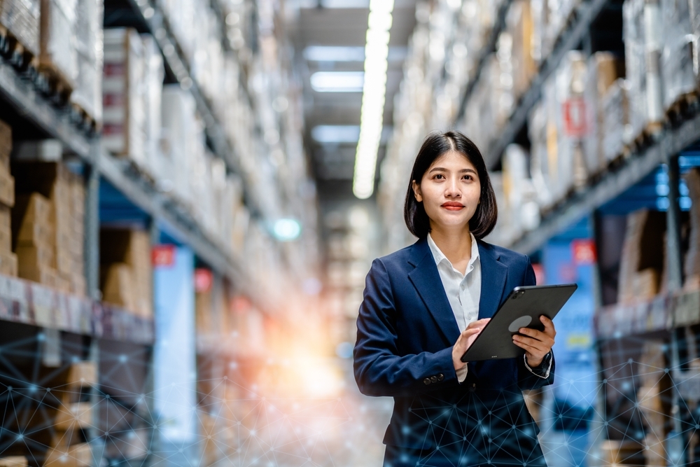 Business woman using a digital tablet to manage stock inventory in warehouse