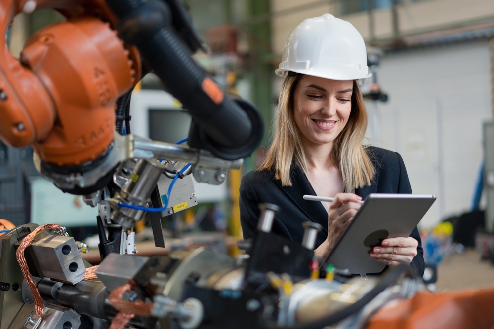 Female chief engineer in modern industrial factory using tablet and making audit
