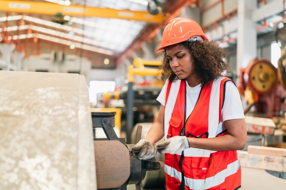 female manufacturing worker operating industrial machine